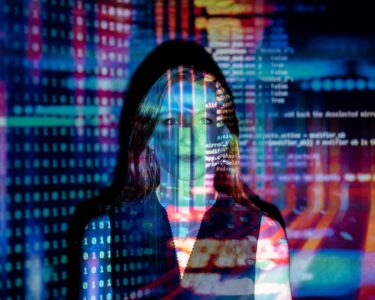 A woman with digital code projections on her face, representing technology and future concepts.